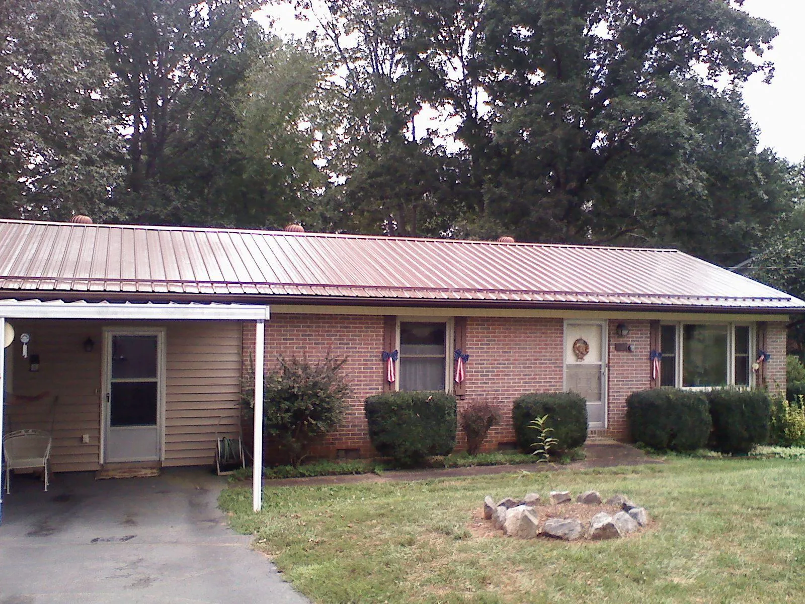 Bronze metal roof and carport on a brick ranch home — Roof Repair work by our crew in Raleigh